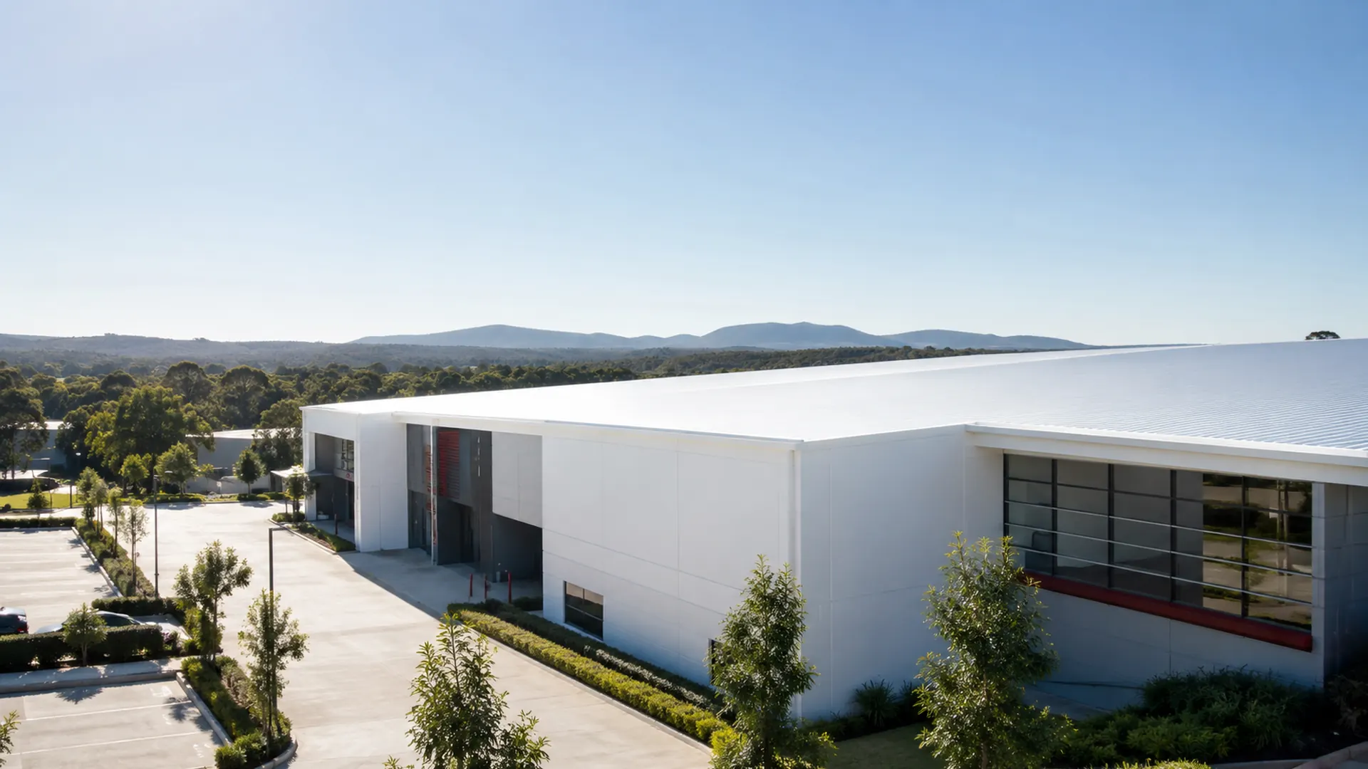 Commercial building with a bright reflective coated roof under clear sky, illustrating a NusCoolWall™ application scenario