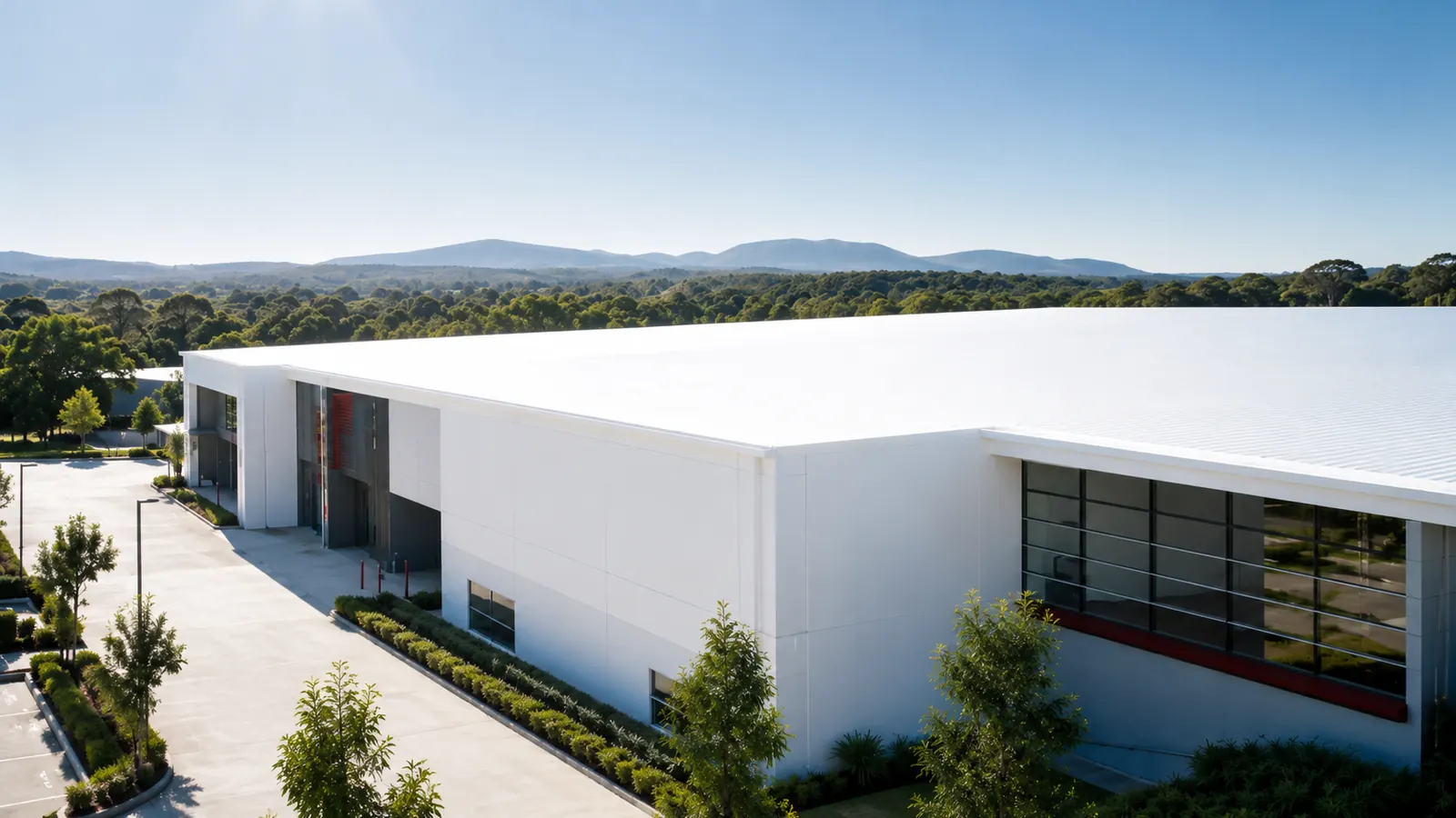 Close-up aerial view of a coated roof and exterior wall junction on a commercial building